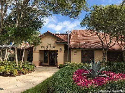 a view of a house with potted plants and a large tree