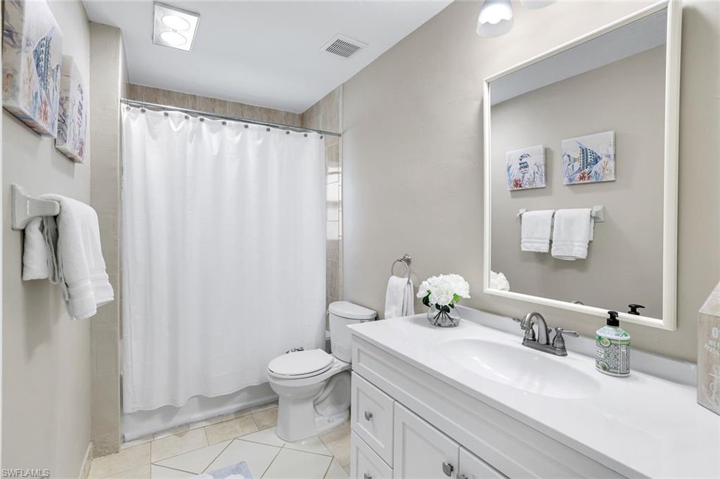 1237 Jamaica Road Marco Island, FL 34145 - Photo 15 of 26 a bathroom with a sink a toilet and shower curtain