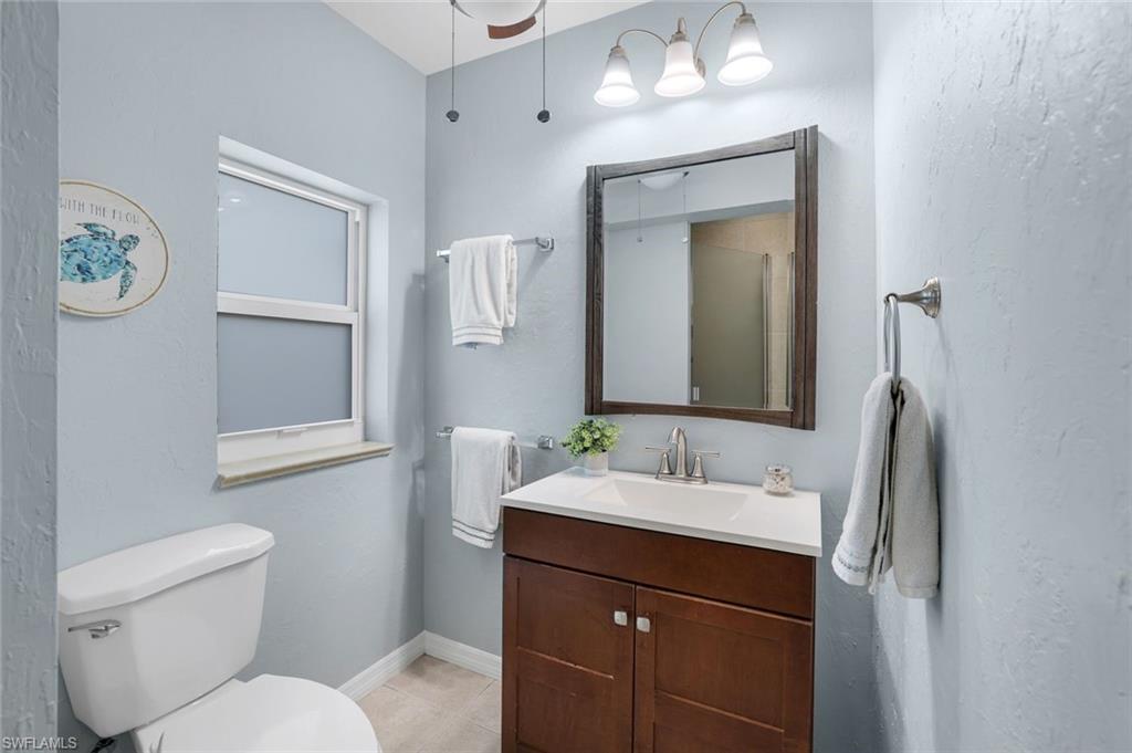 1237 Jamaica Road Marco Island, FL 34145 - Photo 18 of 26 a bathroom with a granite countertop toilet sink and mirror