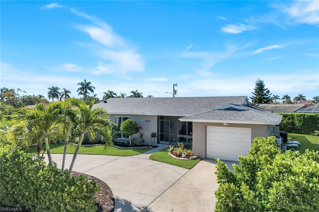 1237 Jamaica Road Marco Island, FL 34145 - Photo 23 of 26 a view of a house with table and chairs under an umbrella