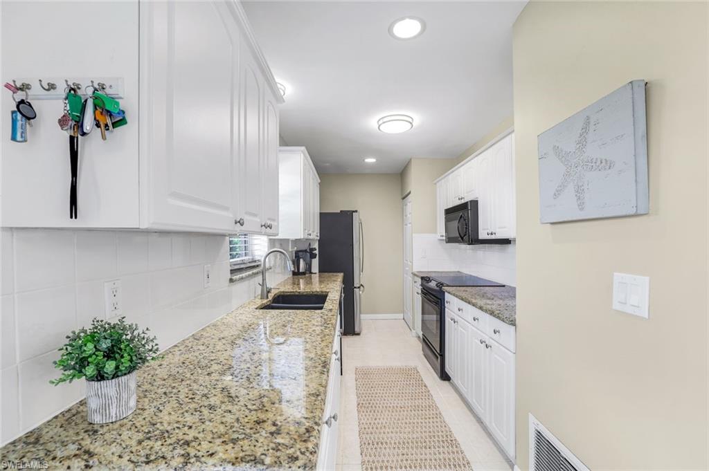 1237 Jamaica Road Marco Island, FL 34145 - Photo 10 of 26 a kitchen with stainless steel appliances kitchen island sink refrigerator and stove