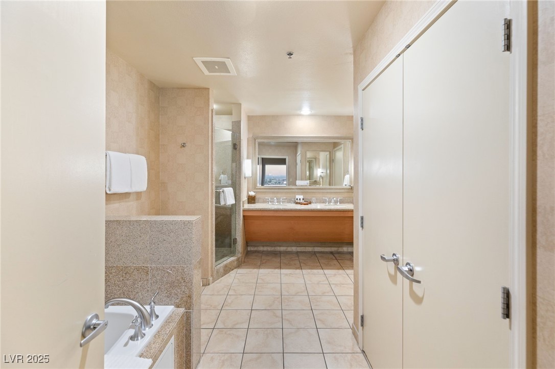 211 East Flamingo Road, Unit 610 Las Vegas, NV 89169 - Photo 15 of 42 Bathroom with a garden tub, visible vents, a stall shower, vanity, and tile patterned flooring