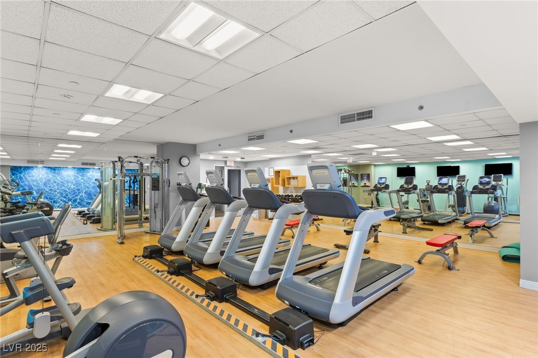 211 East Flamingo Road, Unit 610 Las Vegas, NV 89169 - Photo 33 of 42 Gym with visible vents, a drop ceiling, and wood finished floors