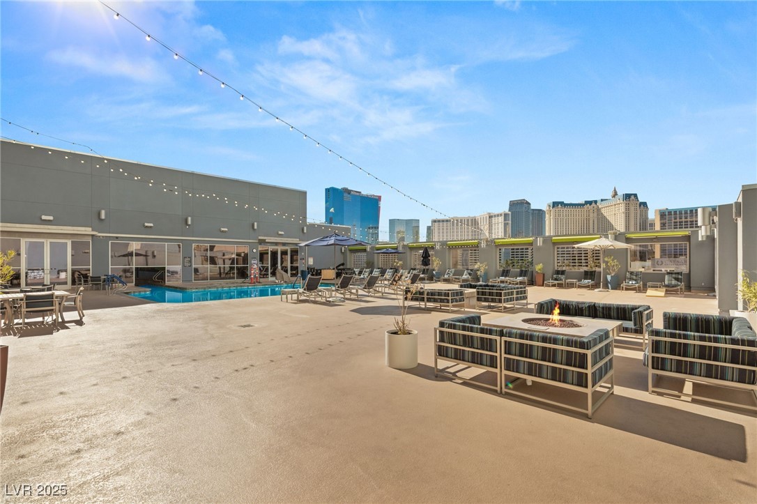 211 East Flamingo Road, Unit 610 Las Vegas, NV 89169 - Photo 35 of 42 View of patio featuring an outdoor fire pit, a view of city, and a community pool