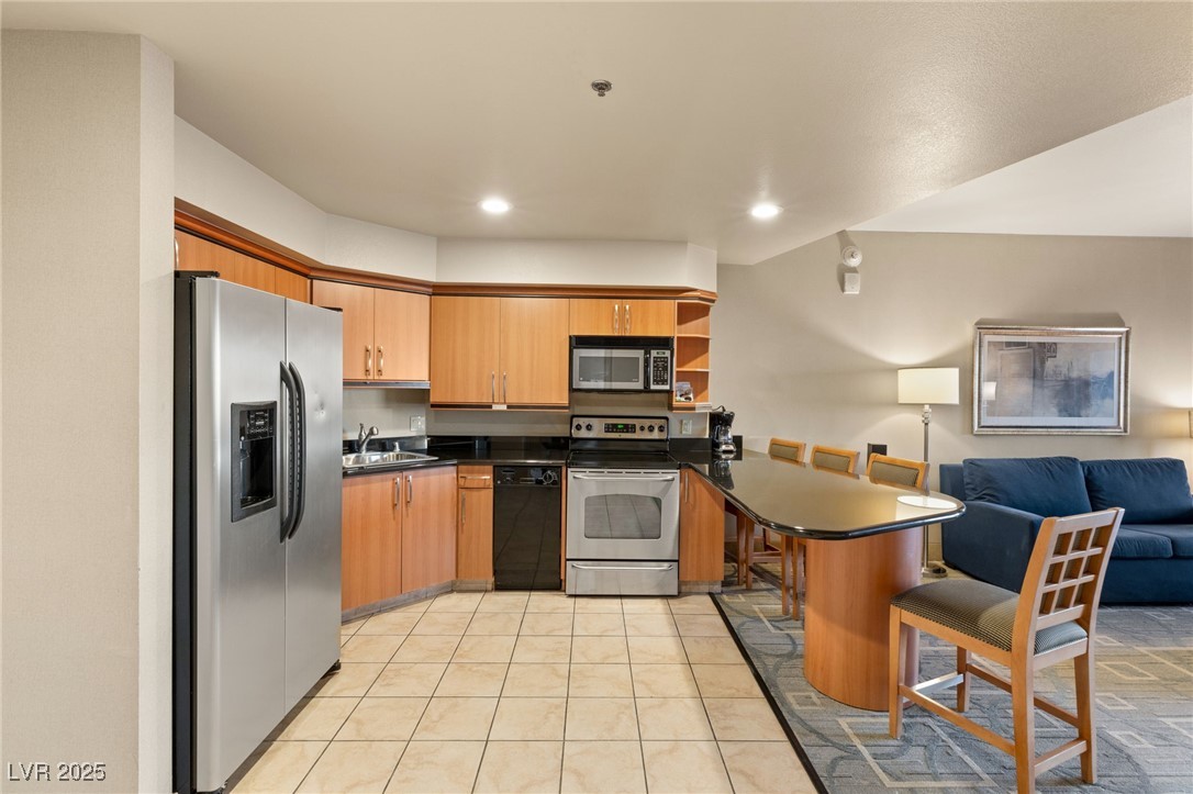 211 East Flamingo Road, Unit 610 Las Vegas, NV 89169 - Photo 42 of 42 Kitchen with dark countertops, appliances with stainless steel finishes, open floor plan, a peninsula, and a sink