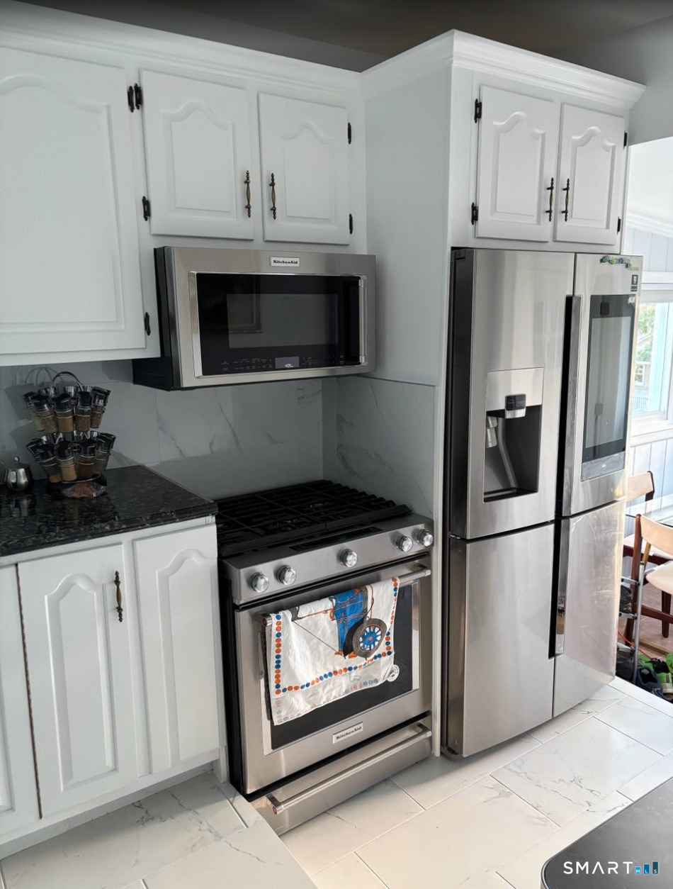 37 Biro Street Fairfield, CT 06825 - Photo 18 of 21 a kitchen with stainless steel appliances granite countertop a refrigerator a stove and white cabinets