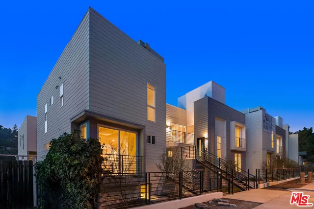 a blue building with a large window and palm trees