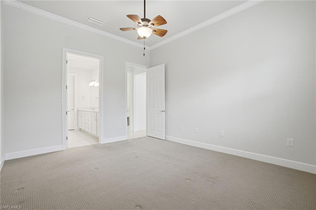 9395 Greyhawk Trail Naples, FL 34120 - Photo 16 of 37 an empty room with a chandelier fan and windows