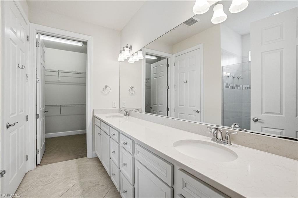 9395 Greyhawk Trail Naples, FL 34120 - Photo 17 of 37 a spacious bathroom with a double vanity sink mirror and shower
