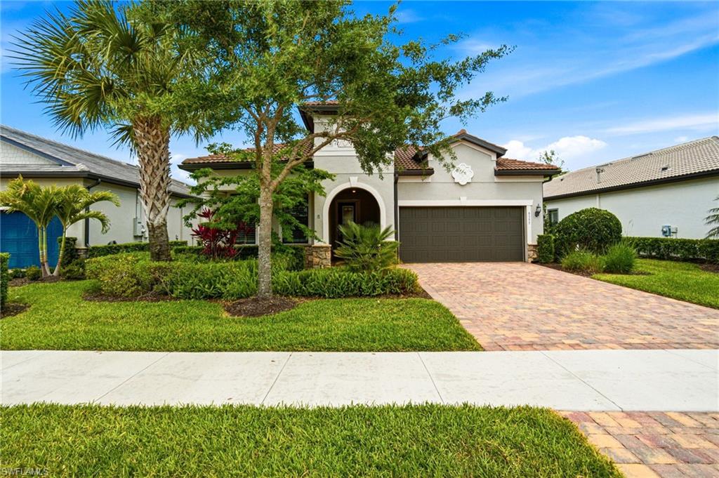 9395 Greyhawk Trail Naples, FL 34120 - Photo 2 of 37 a front view of a house with garden