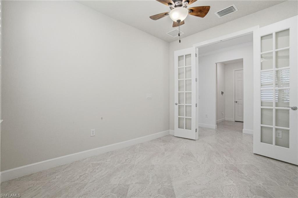 9395 Greyhawk Trail Naples, FL 34120 - Photo 20 of 37 an empty room with a ceiling fan and window