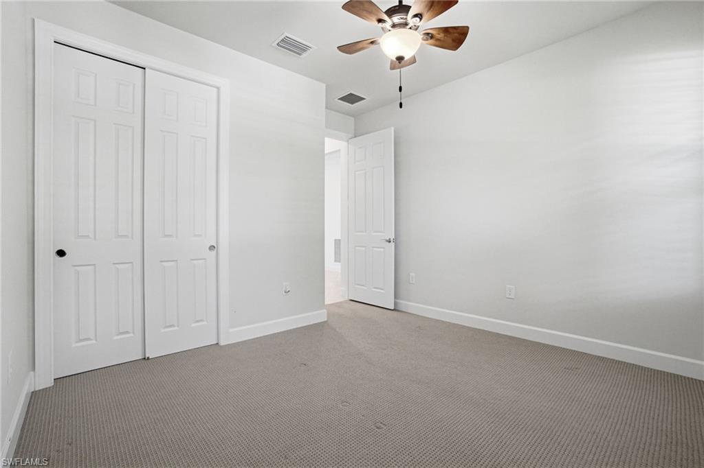 9395 Greyhawk Trail Naples, FL 34120 - Photo 23 of 37 an empty room with a chandelier fan