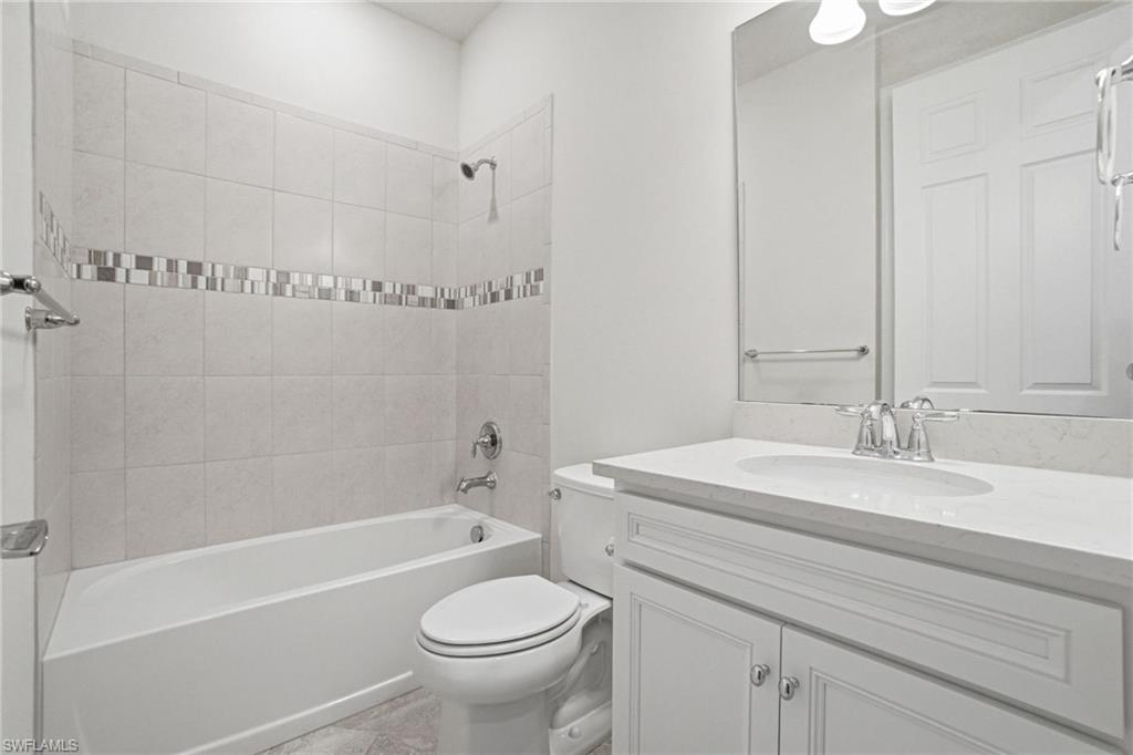 9395 Greyhawk Trail Naples, FL 34120 - Photo 24 of 37 a bathroom with a sink a toilet and a bathtub