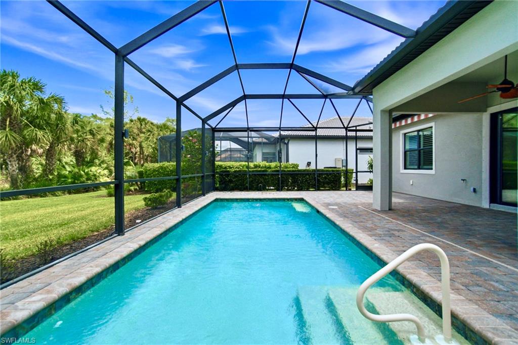 9395 Greyhawk Trail Naples, FL 34120 - Photo 27 of 37 a view of a backyard with table and chairs under an umbrella