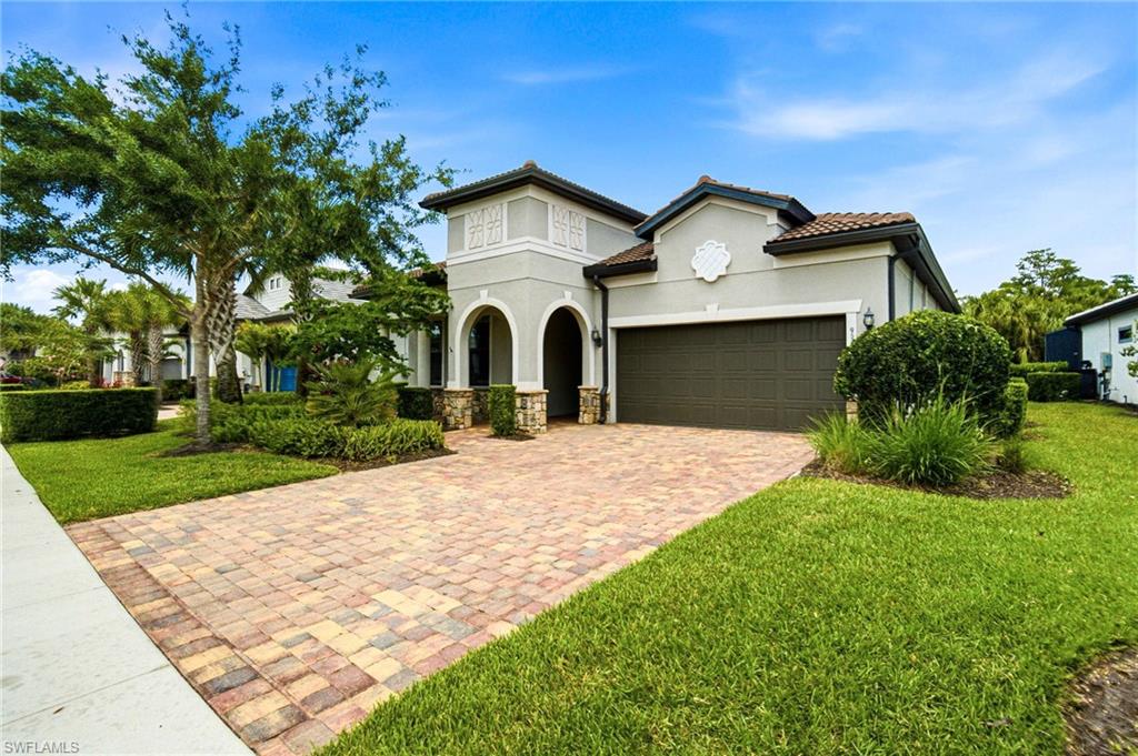 9395 Greyhawk Trail Naples, FL 34120 - Photo 33 of 37 Two-car attached climate-controlled garage with epoxy flooring, a private den with glass French doors, attractive stone detailingon the front elevation, and extensive landscape lighting throughout the property.