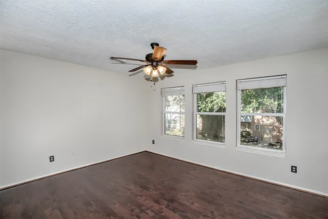 an empty room with a window and a fan
