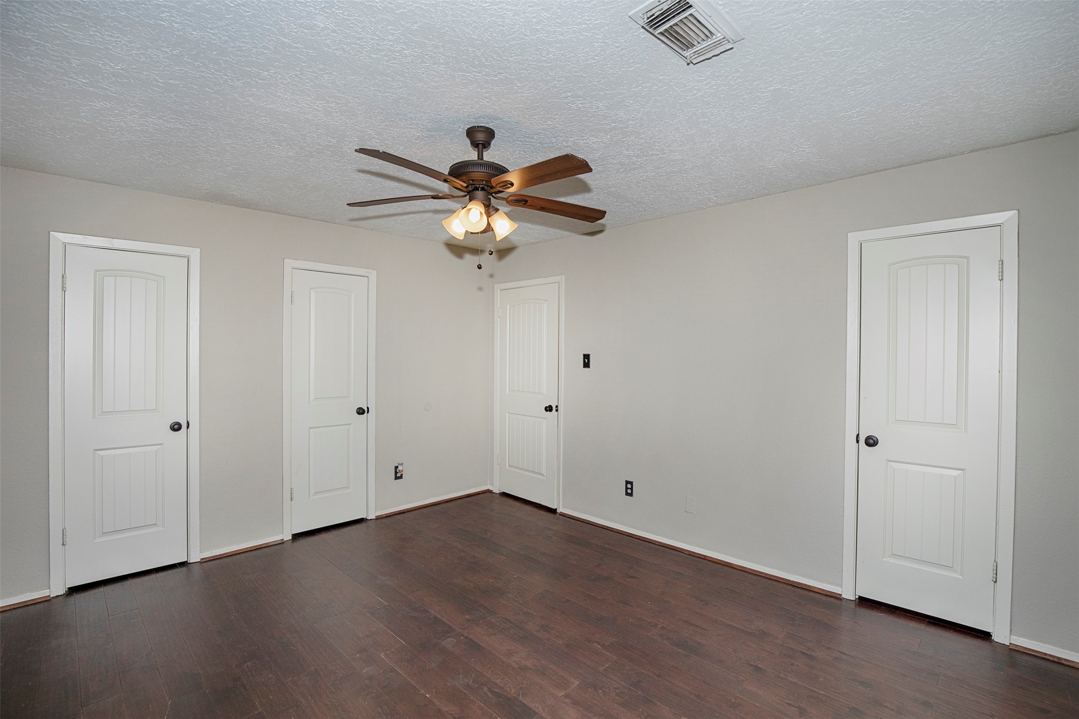 431 Sunset Drive, Unit 2 Dickinson, TX 77539 - Photo 17 of 25 an empty room with wooden floor and a ceiling fan
