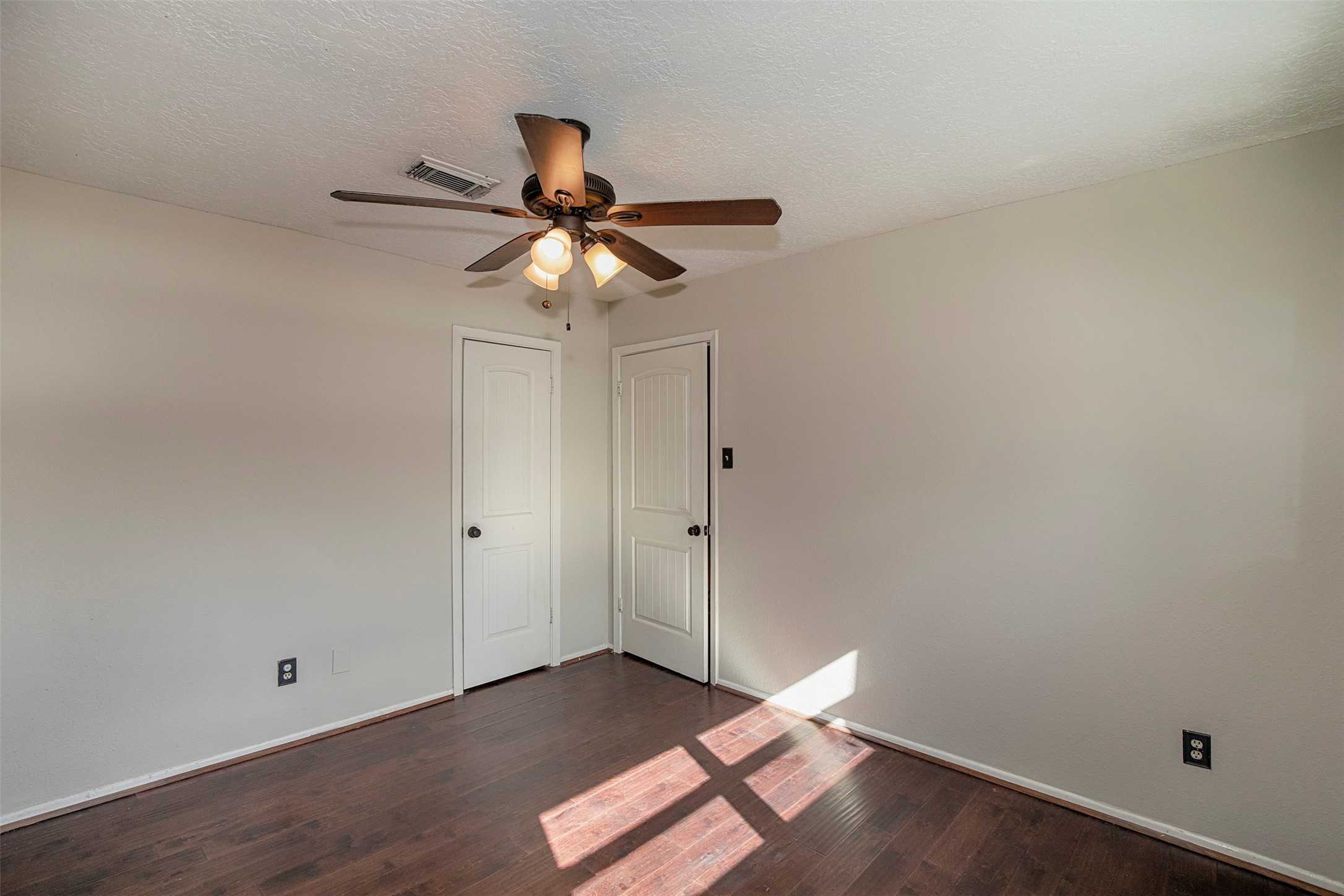431 Sunset Drive, Unit 2 Dickinson, TX 77539 - Photo 19 of 25 an empty room with wooden floor fan and windows