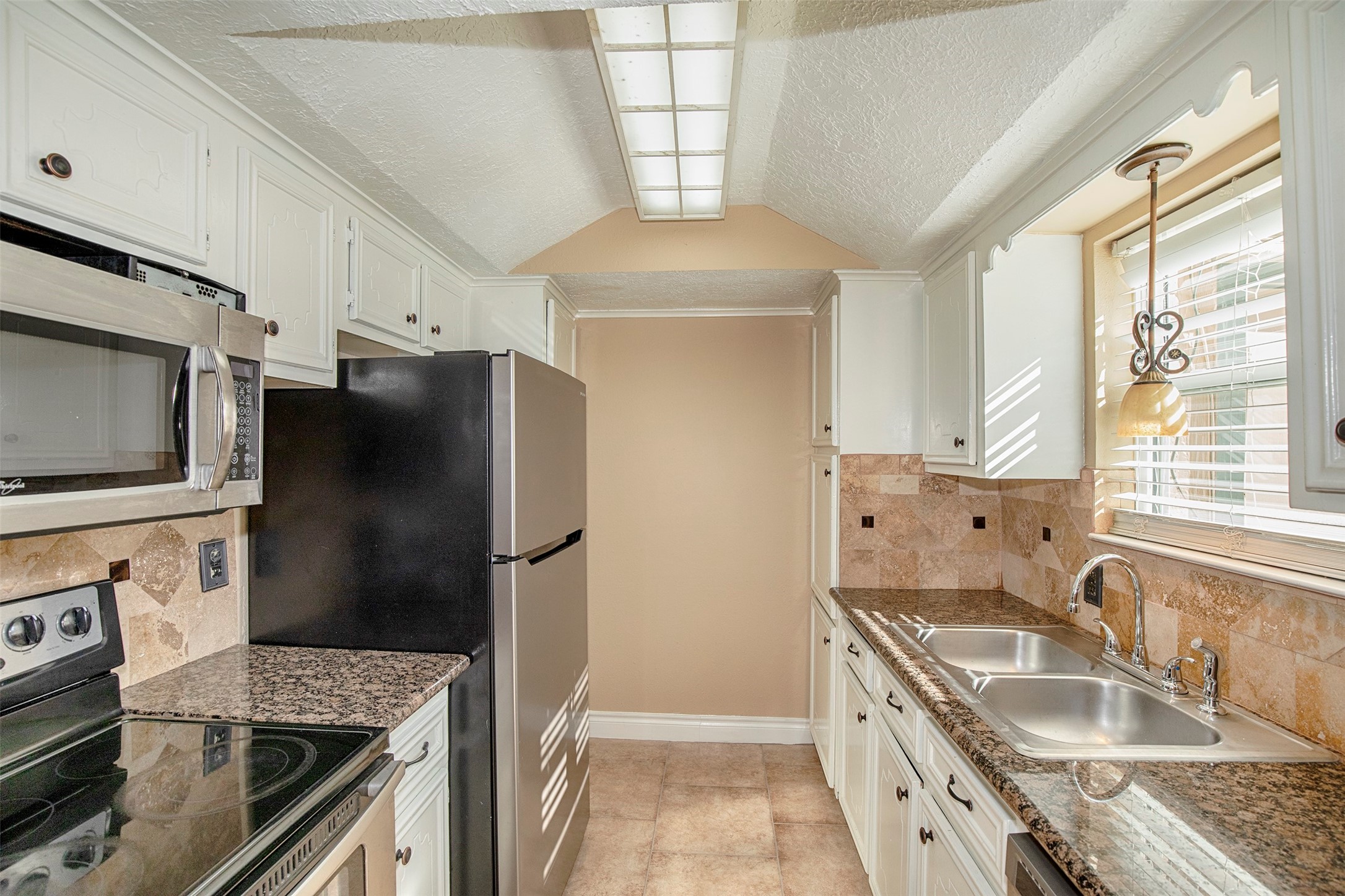 431 Sunset Drive, Unit 2 Dickinson, TX 77539 - Photo 4 of 25 a kitchen with granite countertop a sink stove and refrigerator