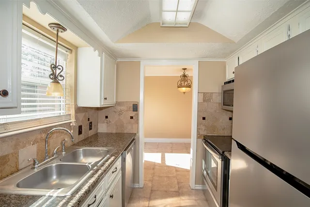 a kitchen with stainless steel appliances a sink and a refrigerator