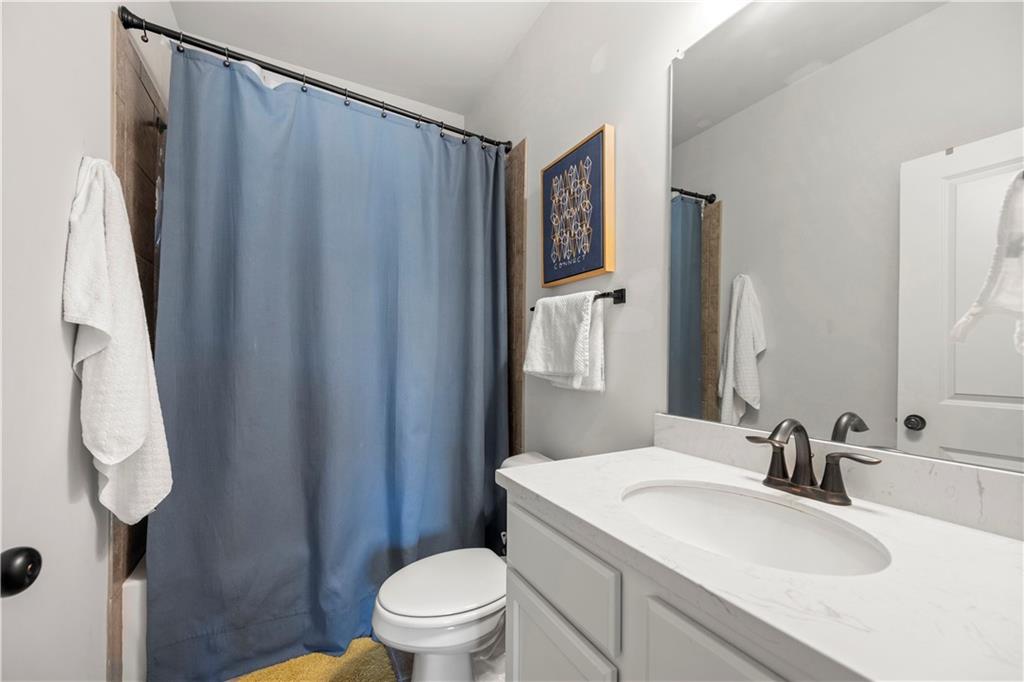 130 Sycamore Row Atlanta, GA 30331 - Photo 21 of 42 a bathroom with a sink a toilet a mirror and shower curtain
