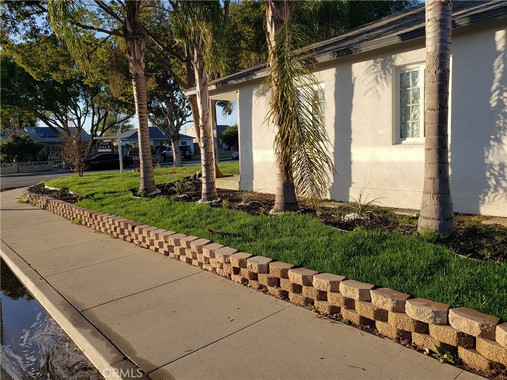 13185 14th Street Chino, CA 91710 - Photo 11 of 42 a front view of a house with a yard and potted plants
