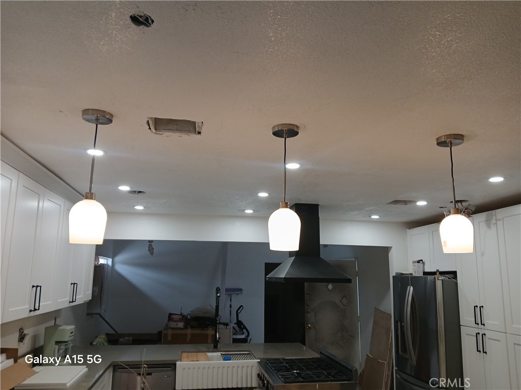 13185 14th Street Chino, CA 91710 - Photo 23 of 42 a large kitchen with a stove a refrigerator a oven a dining table and chairs