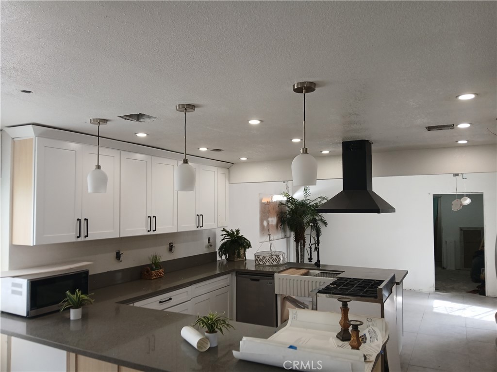 13185 14th Street Chino, CA 91710 - Photo 25 of 42 a kitchen with a refrigerator a sink and white cabinets