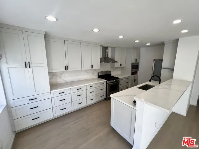 a kitchen with stainless steel appliances granite countertop a sink and a stove