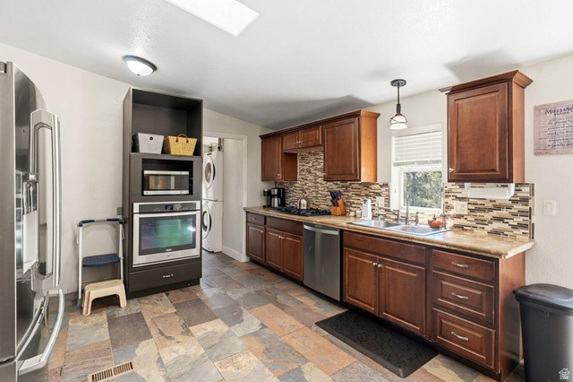 327 North Lodge Road Central, UT 84722 - Photo 9 of 45 Kitchen featuring slate-style tile flooring, wood cabinetry, stainless steel appliances, a multi-tone tile backsplash, and a skylight