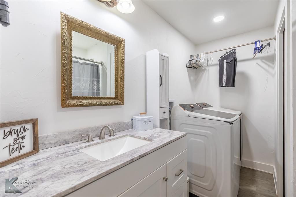 801 Highway 153 Wingate, TX 79566 - Photo 19 of 39 a bathroom with a granite countertop sink vanity mirror and toilet