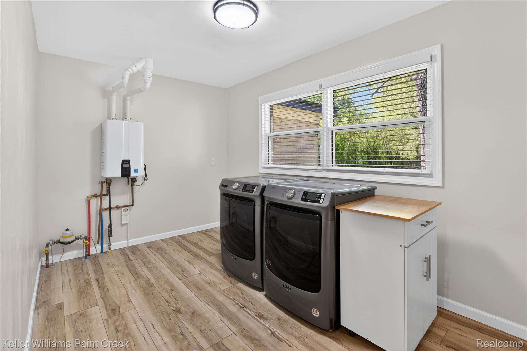 2942 Tatham Road Saginaw, MI 48601 - Photo 26 of 59 Laundry room with light wood-style floors, separate washer and dryer, and tankless water heater