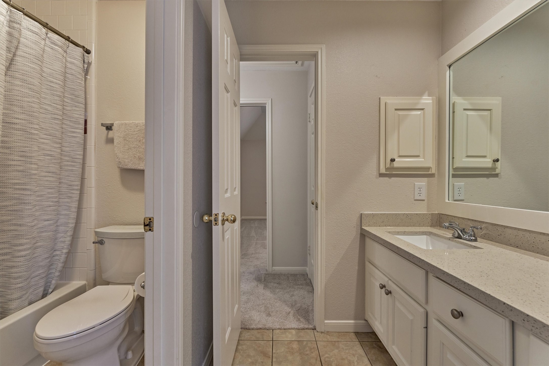 16707 Avenfield Road Tomball, TX 77377 - Photo 32 of 50 a bathroom with a granite countertop toilet a sink and a mirror
