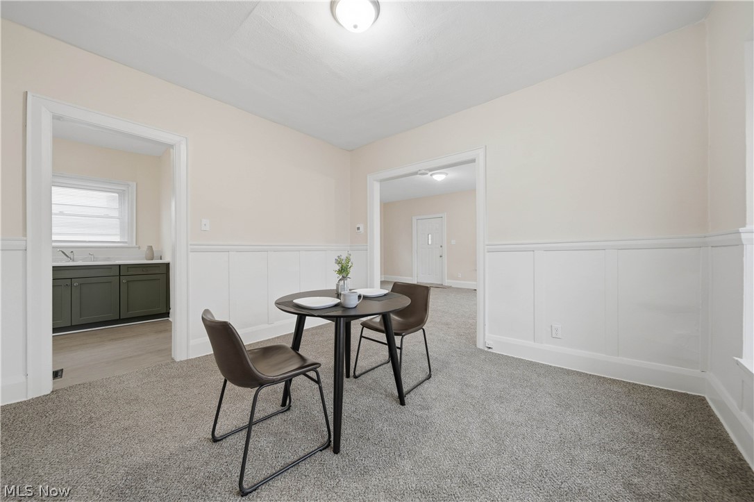 225 Cranz Place Akron, OH 44310 - Photo 8 of 34 Dining area featuring a wainscoted wall, a decorative wall, and light colored carpet