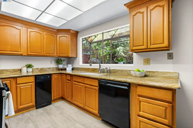 a kitchen with stainless steel appliances granite countertop a sink stove and cabinets