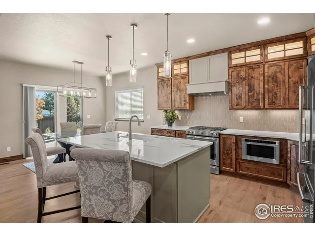 a view of a dining room with furniture a chandelier and wooden floor