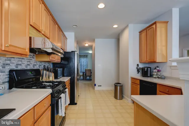 a kitchen with stainless steel appliances granite countertop a stove top oven a sink a counter space and cabinets