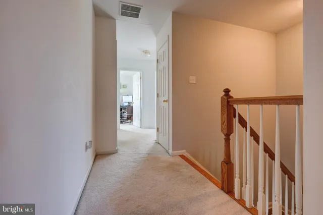 a view of a hallway with wooden floor and entryway