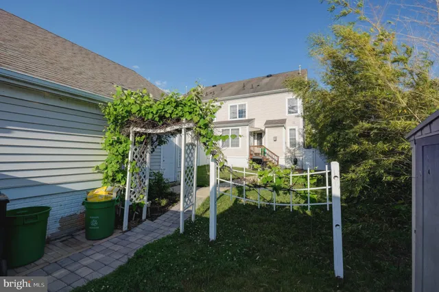a view of a chair and table in backyard of the house