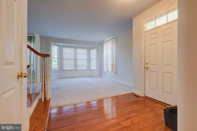 an empty room with wooden floor and a window