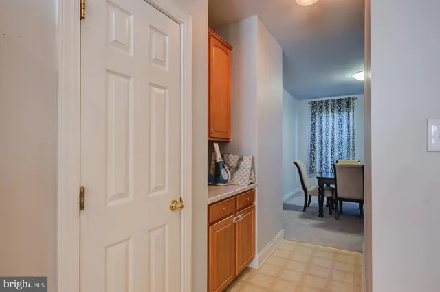 a view of a hallway to a livingroom with furniture and workspace