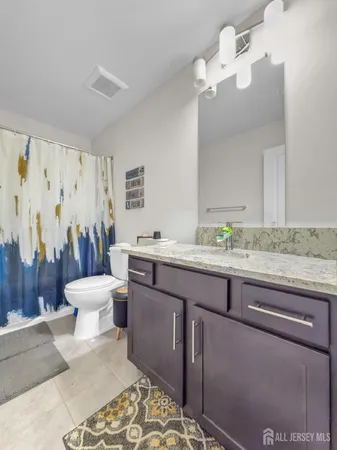 a bathroom with a granite countertop sink a toilet and a mirror