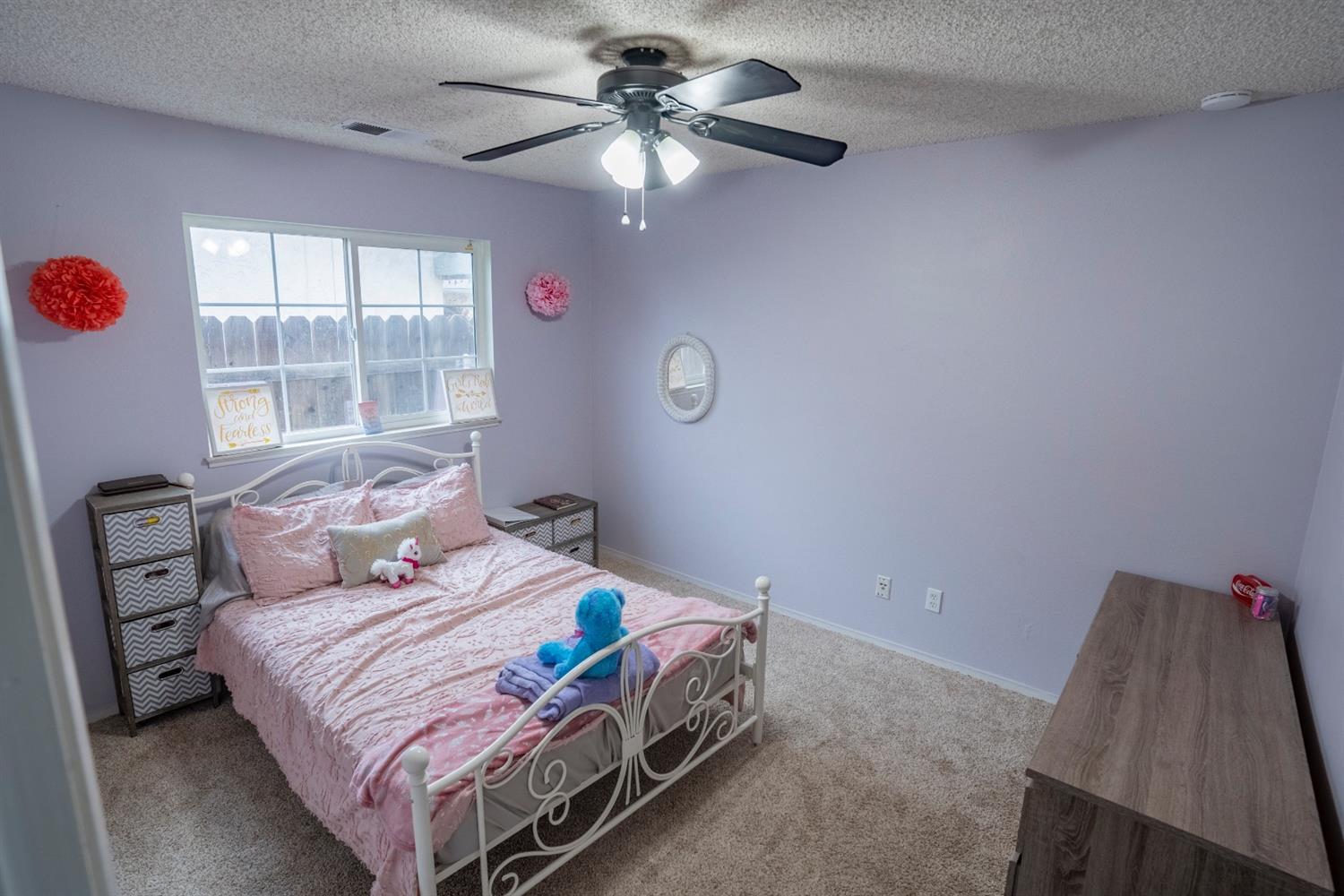 1607 Ashlan Avenue Clovis, CA 93611 - Photo 11 of 17 a bedroom with a bed and a chandelier