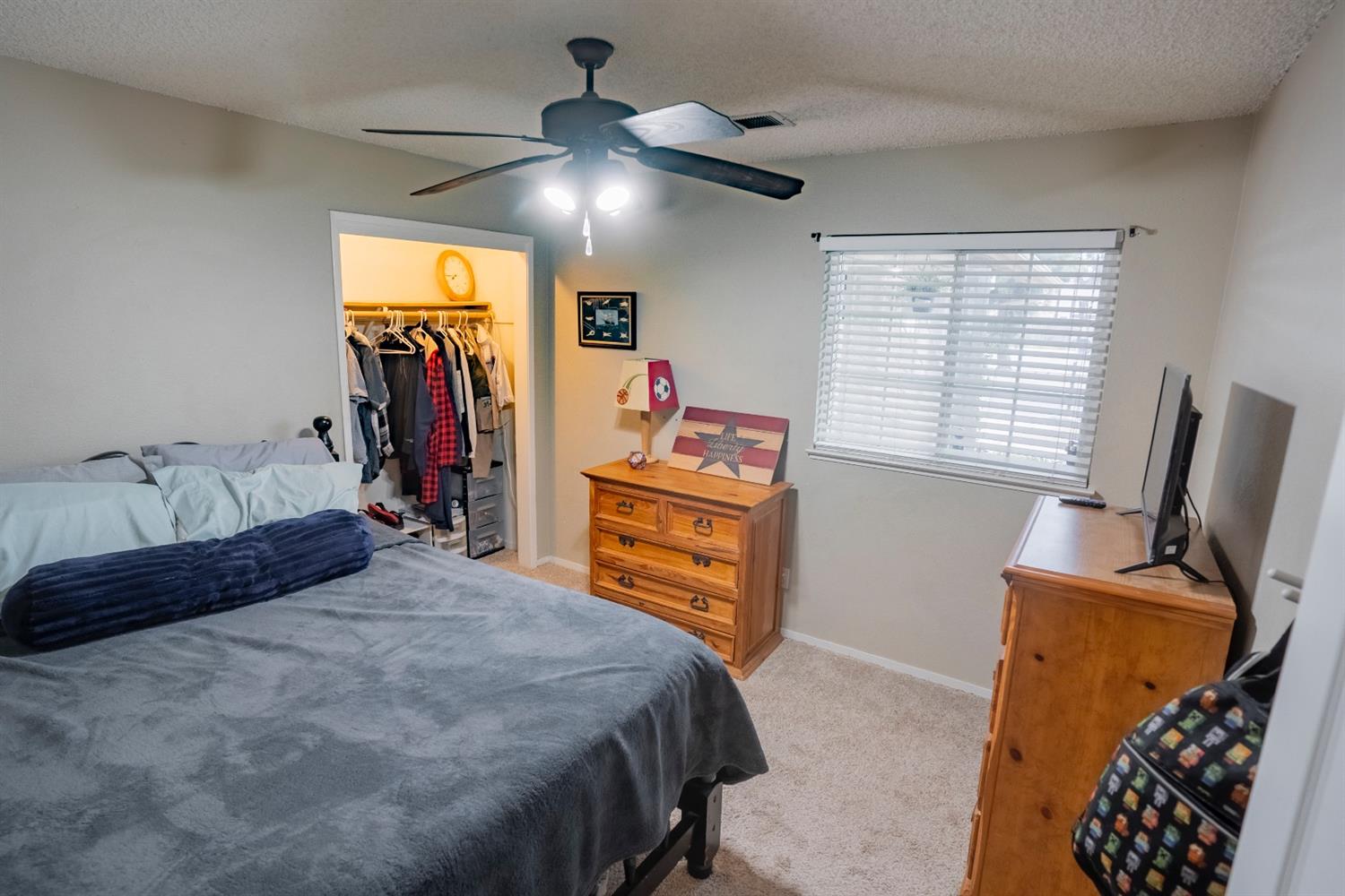 1607 Ashlan Avenue Clovis, CA 93611 - Photo 12 of 17 a bedroom with a bed and a flat tv screen on dresser