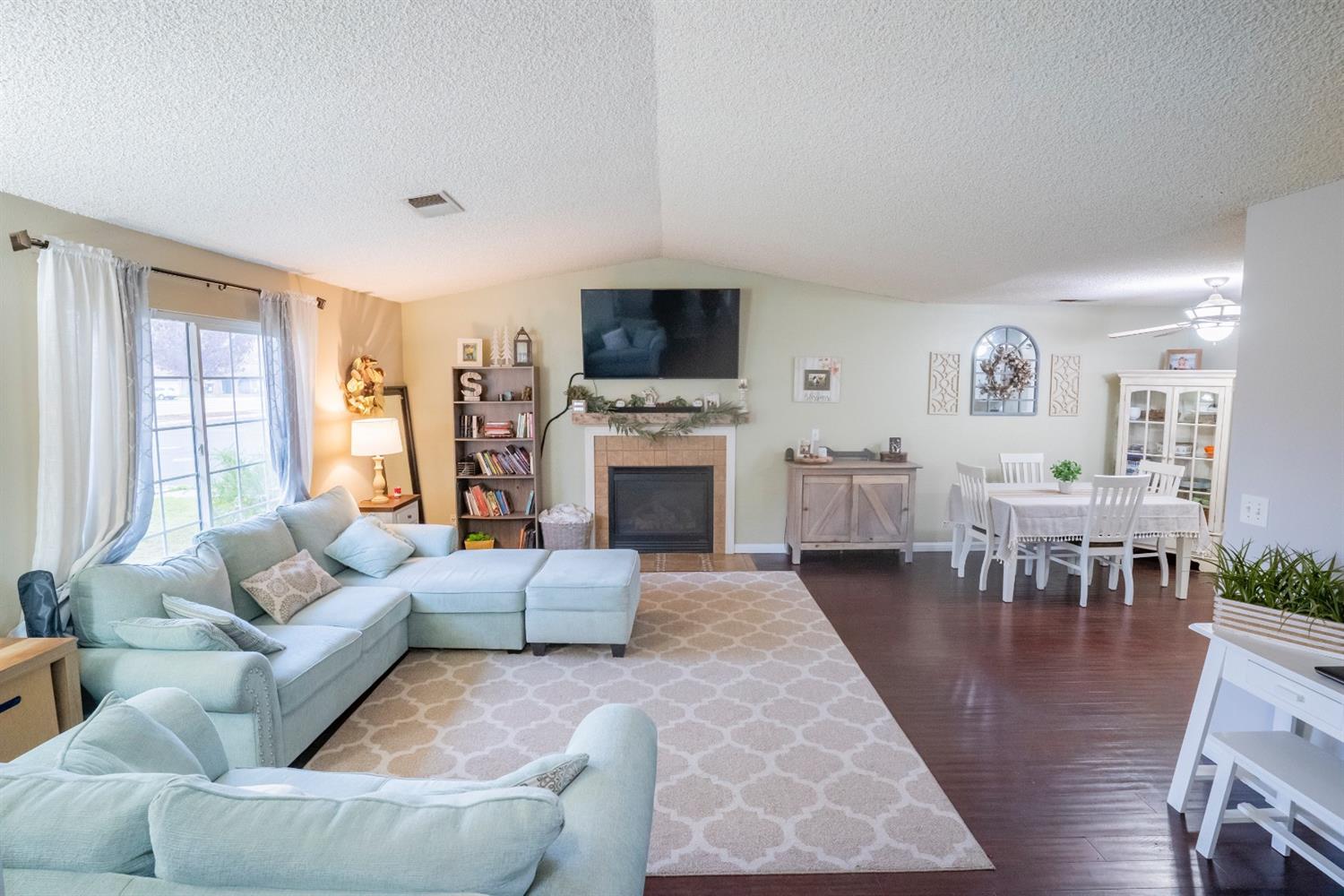 1607 Ashlan Avenue Clovis, CA 93611 - Photo 7 of 17 a living room with furniture a flat screen tv and a fireplace