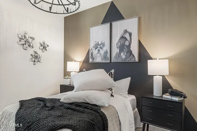 a bedroom with a bed and painting on the wall