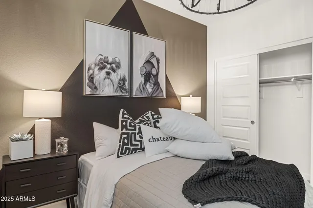 a bedroom with a bed and a lamp on dresser