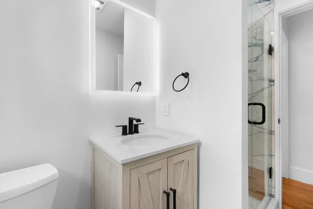 a bathroom with a sink a toilet and shower