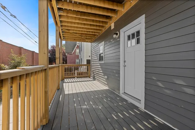 a view of a balcony with wooden floor and floor to ceiling window