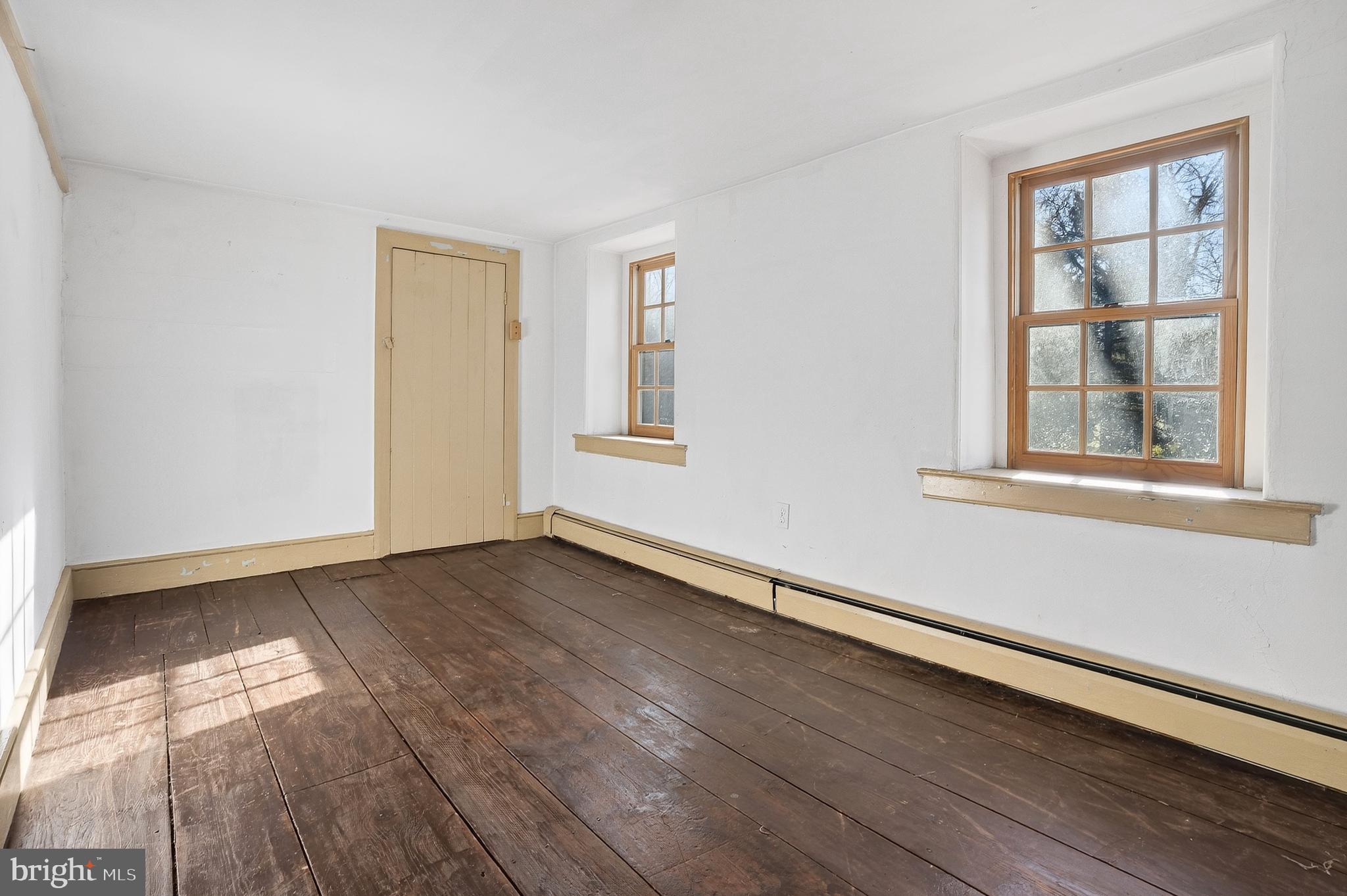 201 Pine Swamp Road Elverson, PA 19520 - Photo 36 of 60 a view of an empty room with wooden floor and a window